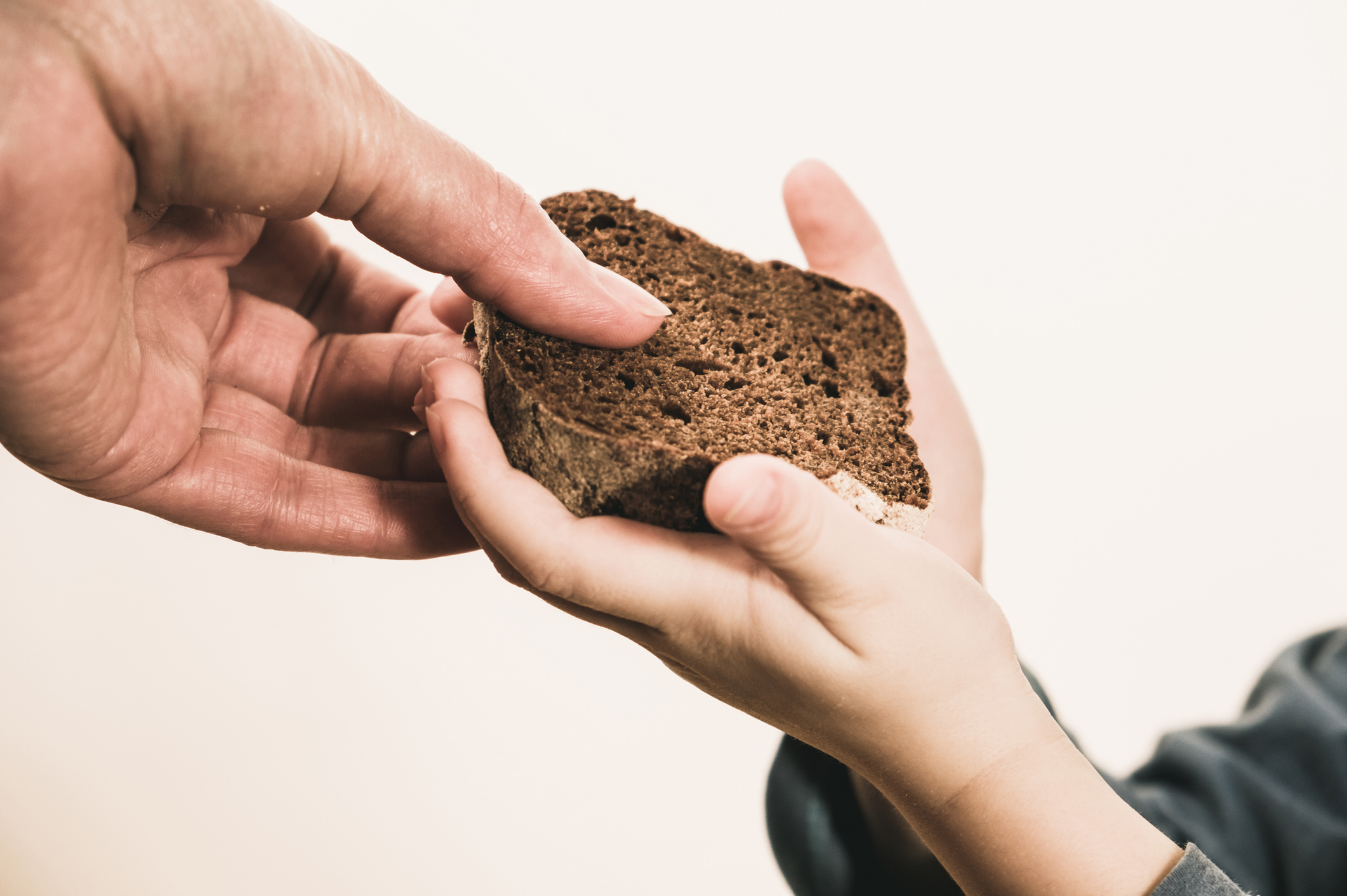 Two beggar hands palms up with cheap dirty bread. Poor children and people donations Volunteers Concept.