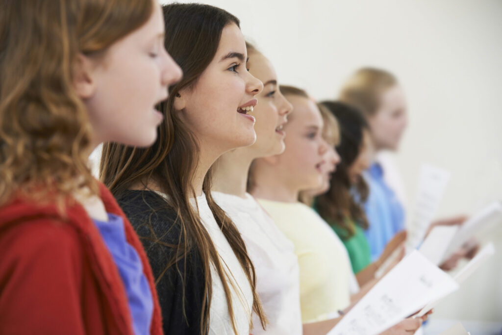 Group Of School Children Singing In Choir Together